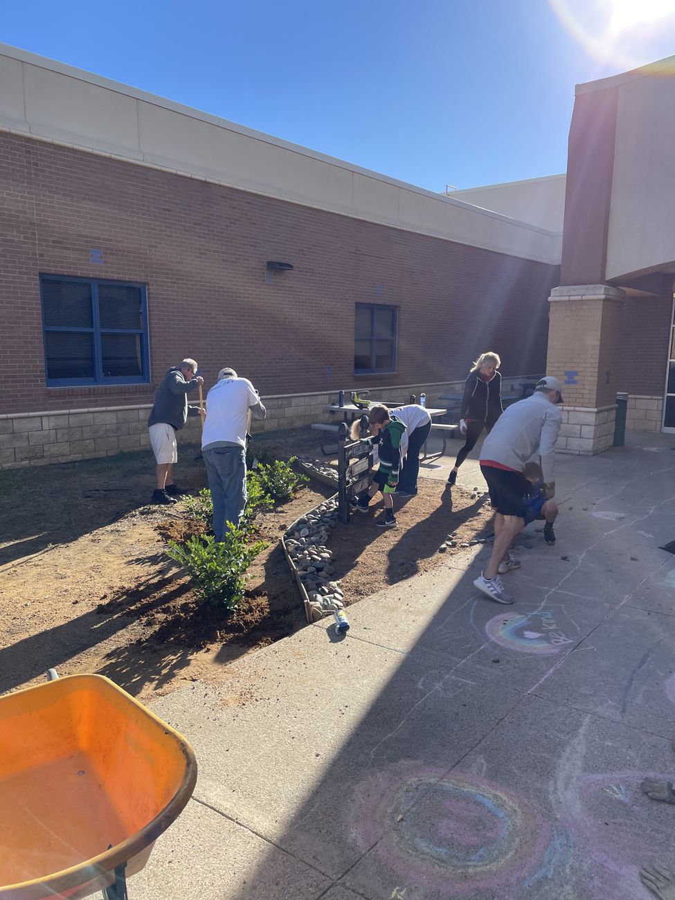 Volunteers planting shrubs and spreading mulch in a new garden bed